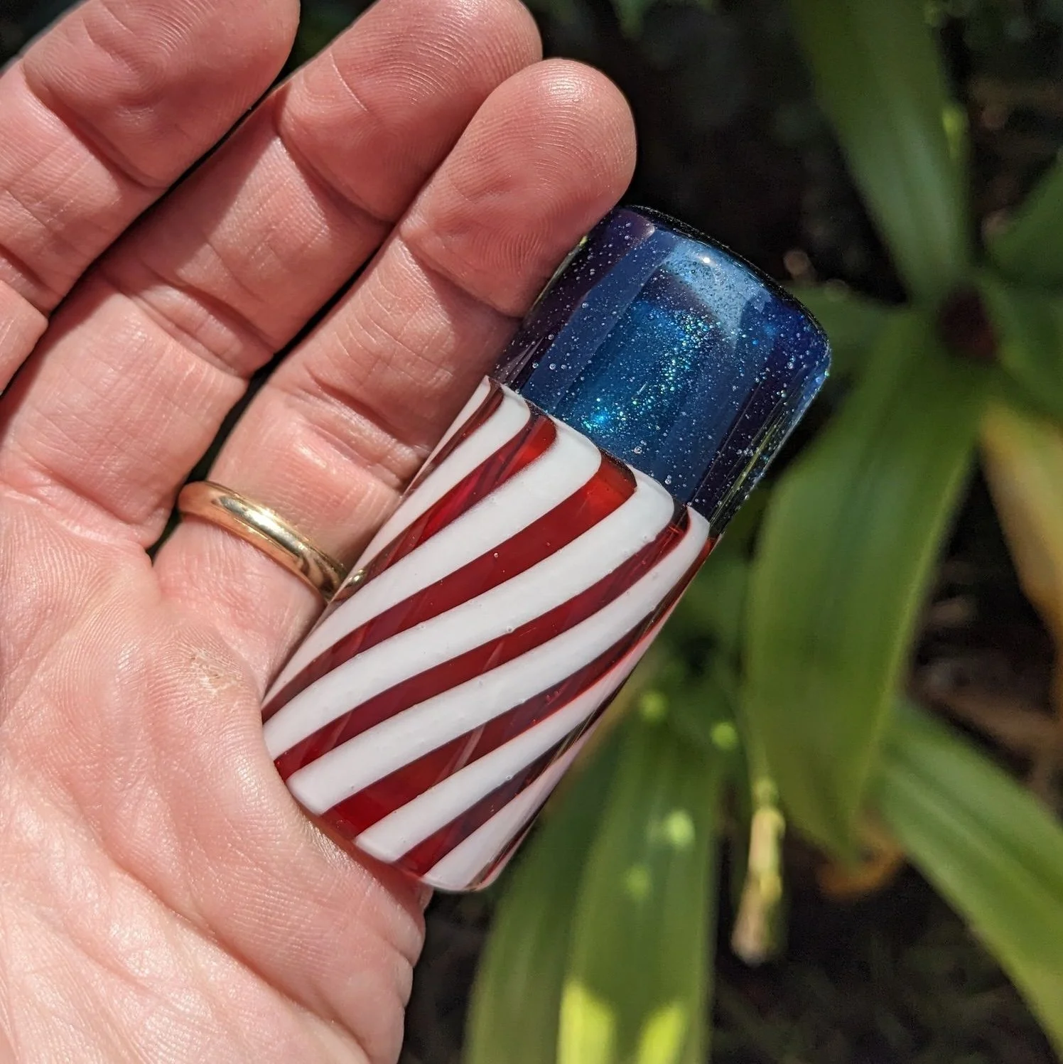 The Liberty Slide #1, handcrafted red white and blue glass guitar slide shown in hand