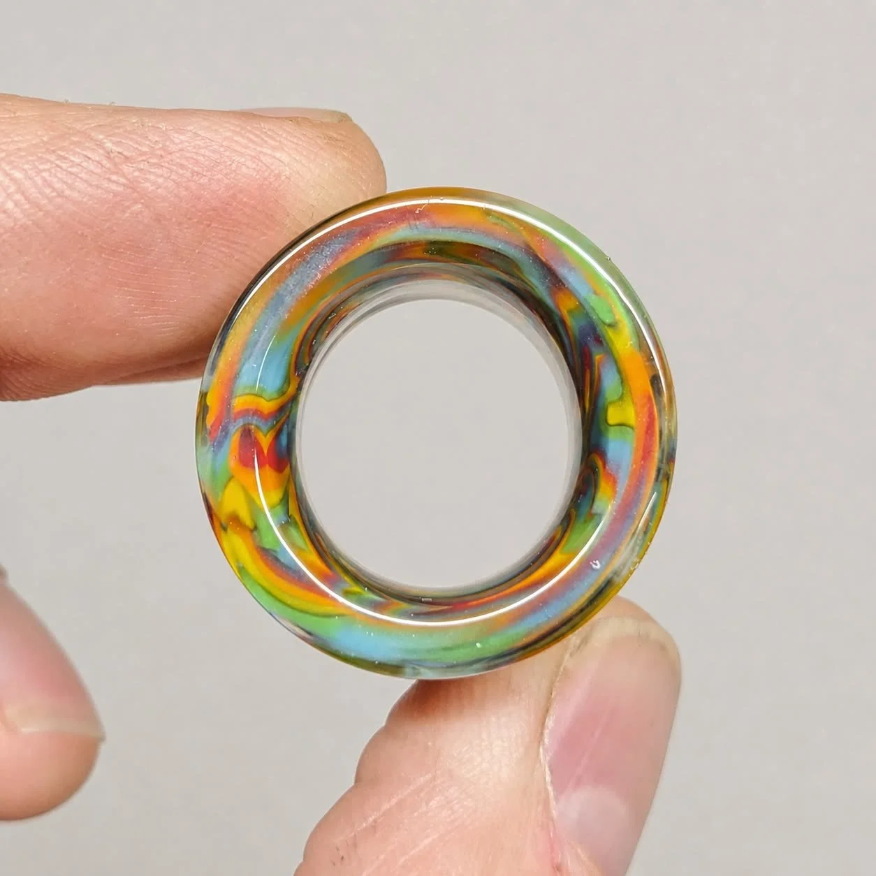 End view of Tie Dye Spiral Mini non-tapered glass guitar slide showing its heavy wall and small inner diameter
