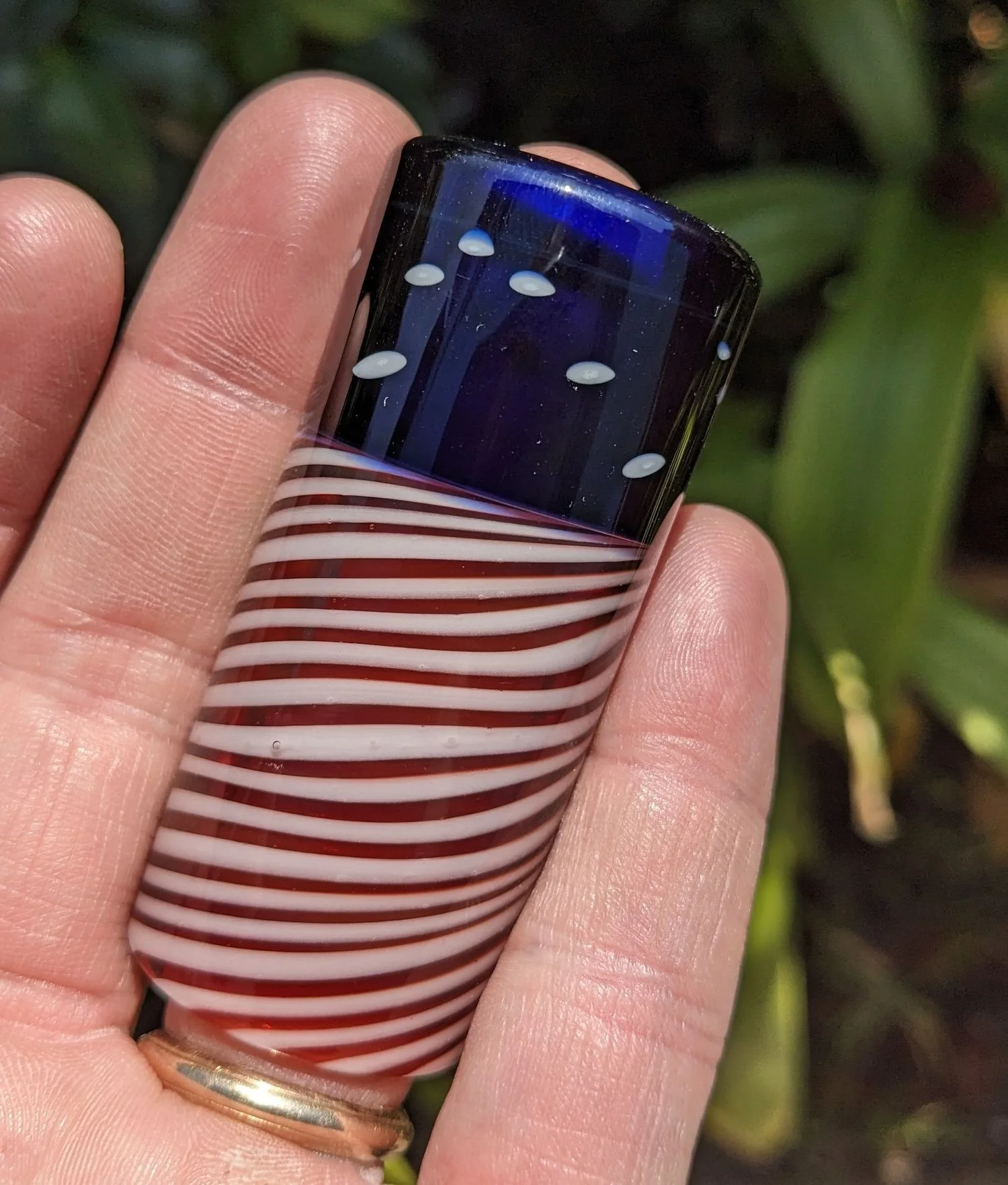 The Liberty Slide #2, handcrafted red white and blue glass guitar slide shown in hand