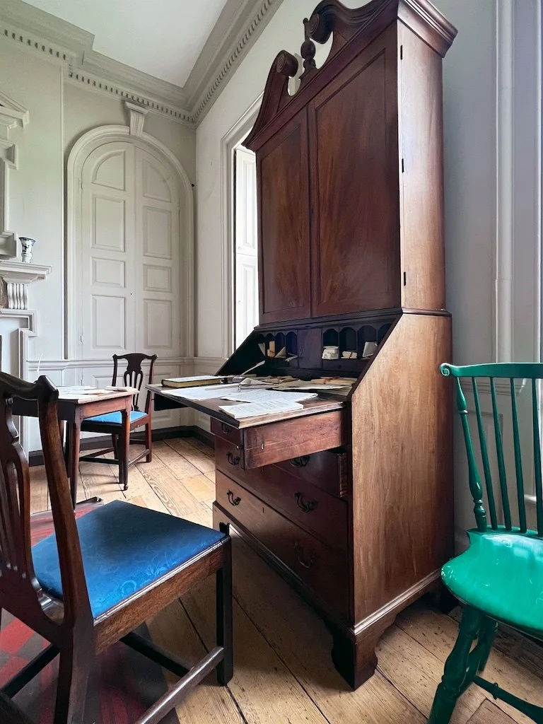 On either side of the fireplace are deep-shelved beaufats (niches) to store and display the tableware, with doors to secure valuable possessions. The desk belonged to George Mason.