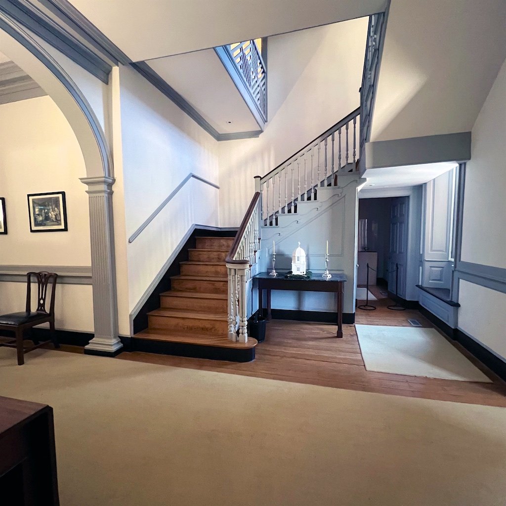 The stair to the upper floors rises from the side of the central passage hallway, allowing for open circulation within the passage