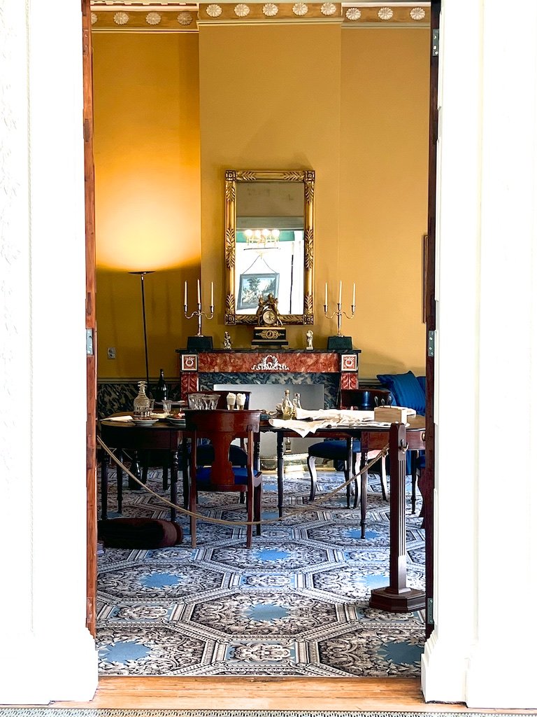 Dining Room: The east parlor served as the dining room. The west parlor, with the salon in between, was the principle receiving parlor for guests. A portrait of Henri Joseph, Baron de Stier, is on the wall.