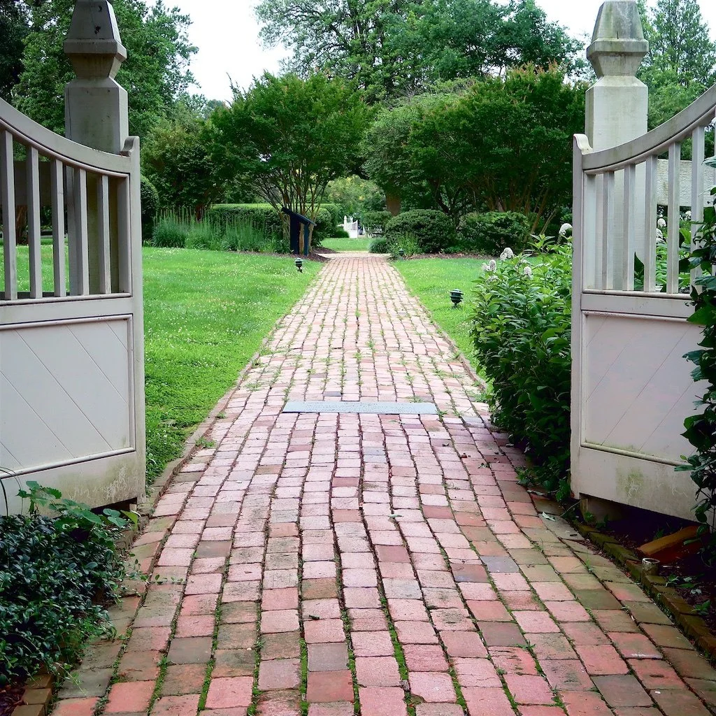 Garden Entrance: Gardens of Woodlawn are a reflection of archaeological survey work. As envisioned by landscape architect Alden Hopkins - two parterres are now planted with roses, summer annuals, and flowering shrubs. 
