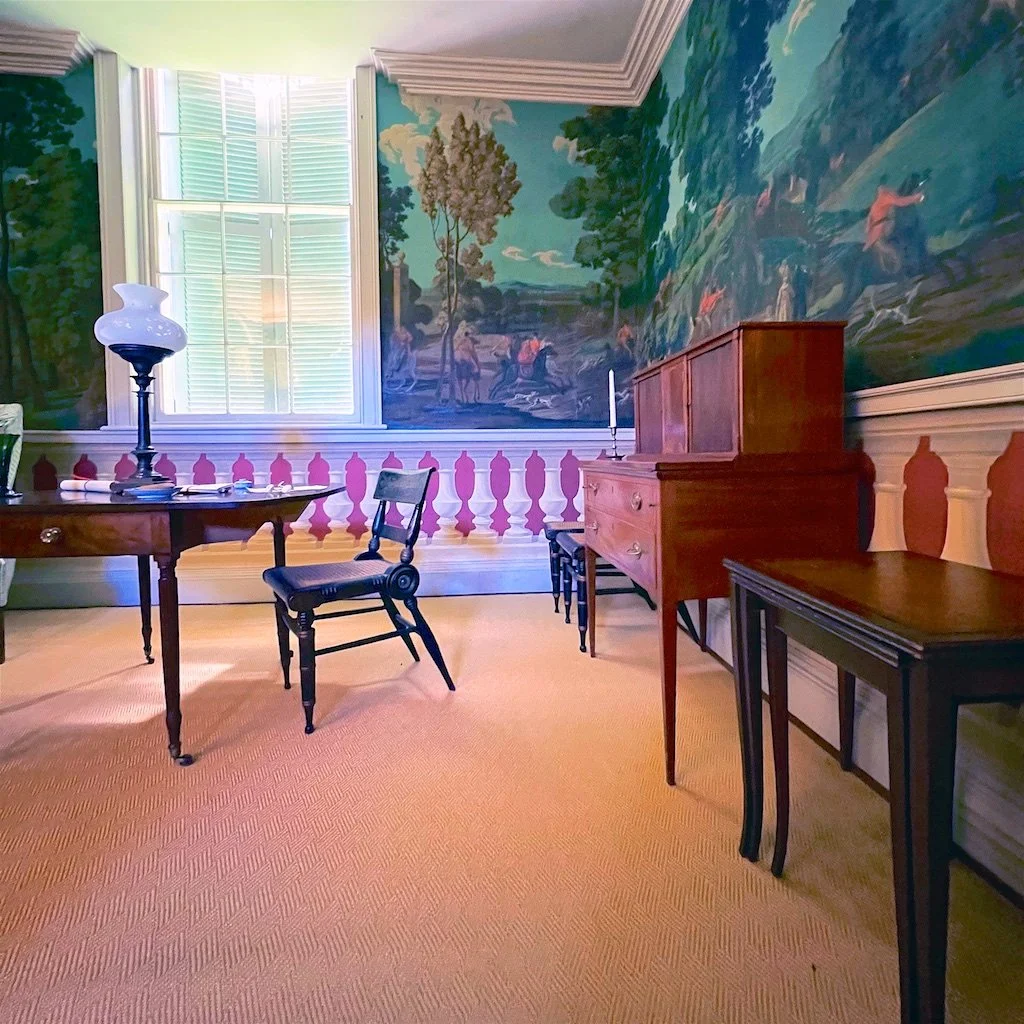 Office: The dedication to the symmetrical exterior meant that inside, windows awkwardly spanned two stories in the library with its historical scenic wallcovering.