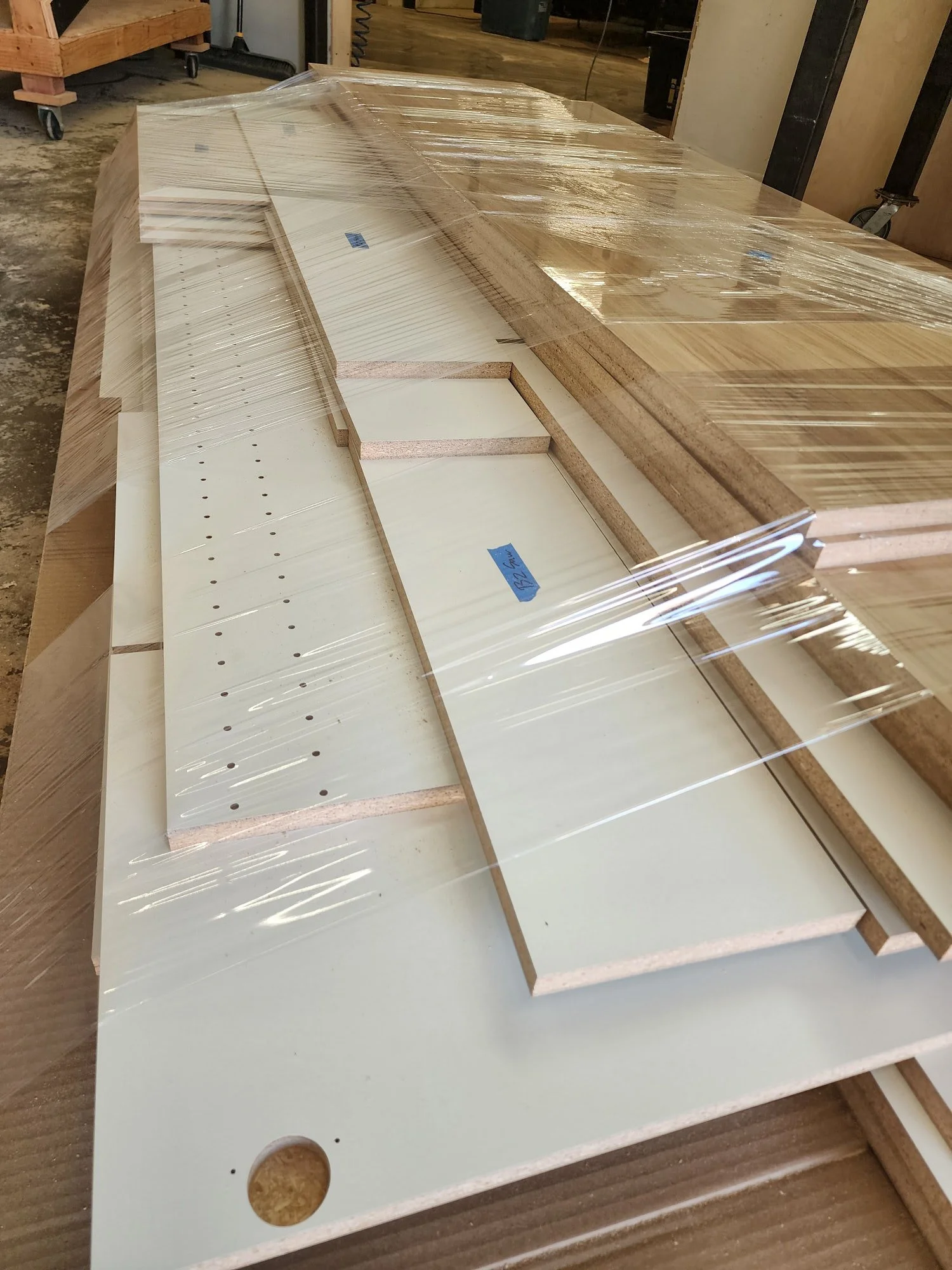Cabinetry parts wrapped in plastic on a pallet