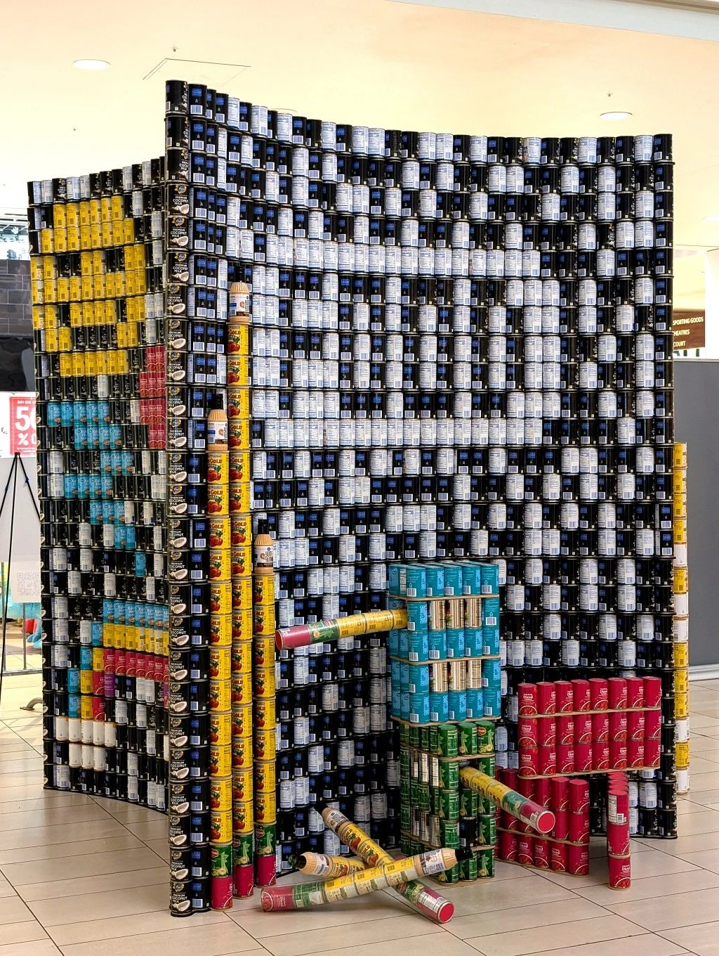 Cans stacked to create an art display that looks like a notebook and pencils