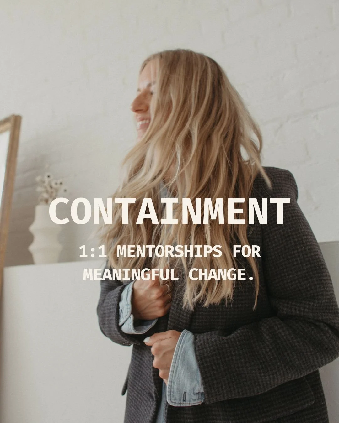 A woman with long blonde hair, wearing a dark blazer and a light-colored shirt, smiling and looking away.