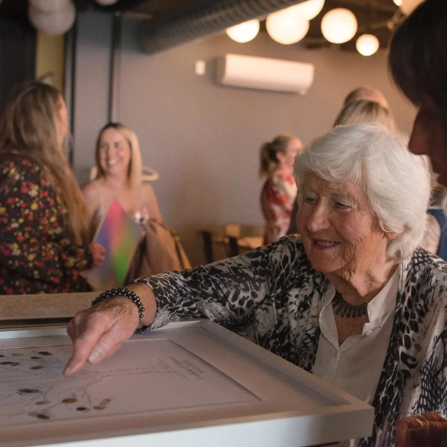 In between the laughter and the music, the dancing and the clinking of glasses, there are moments that almost slip by unnoticed. Like this one. Nana leaning in, carefully pressing her thumbprint onto the family tree. Her hands soft and steady, the sa