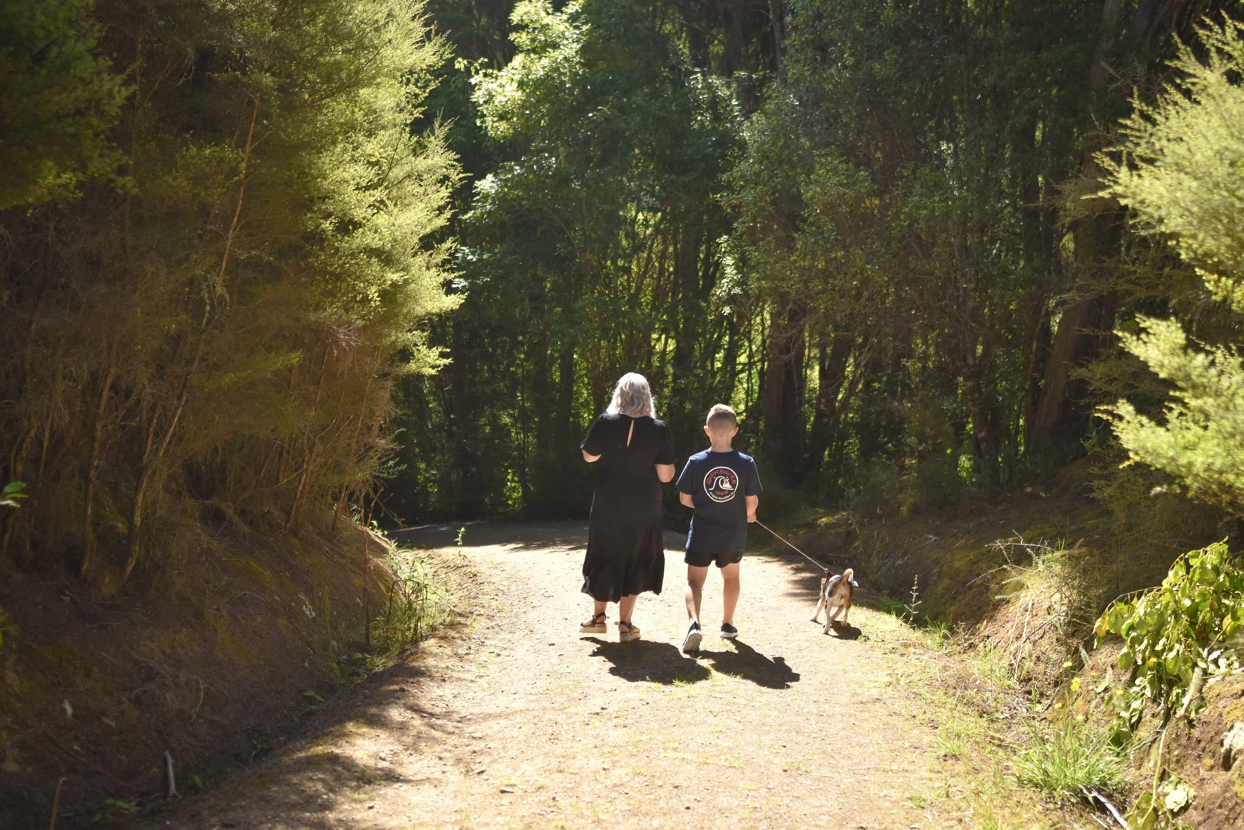 fun natural candid family photography outdoors mother and son walking along a well lit path
