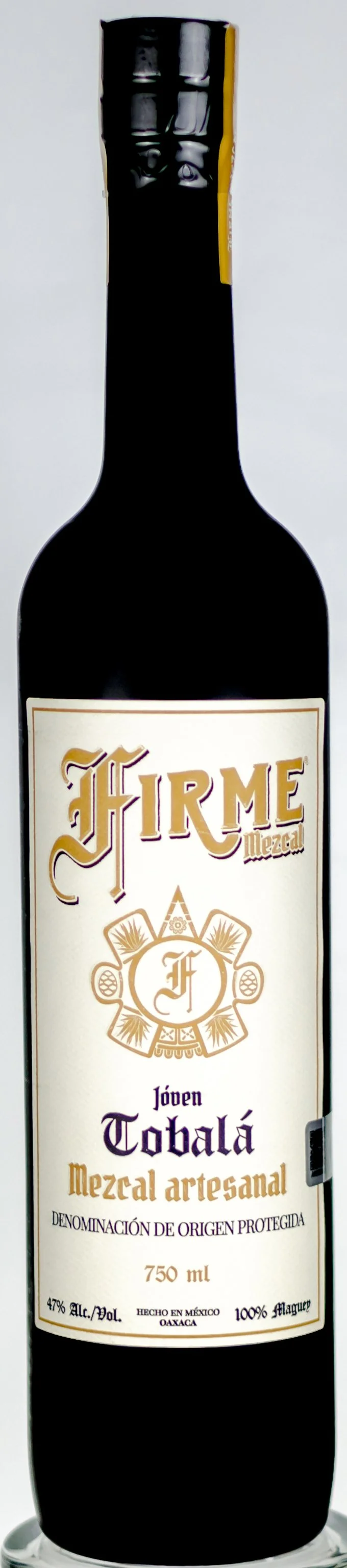 A dark glass bottle of Firme Mezcal Joven Tobalá, 750 ml, with a white and gold label.