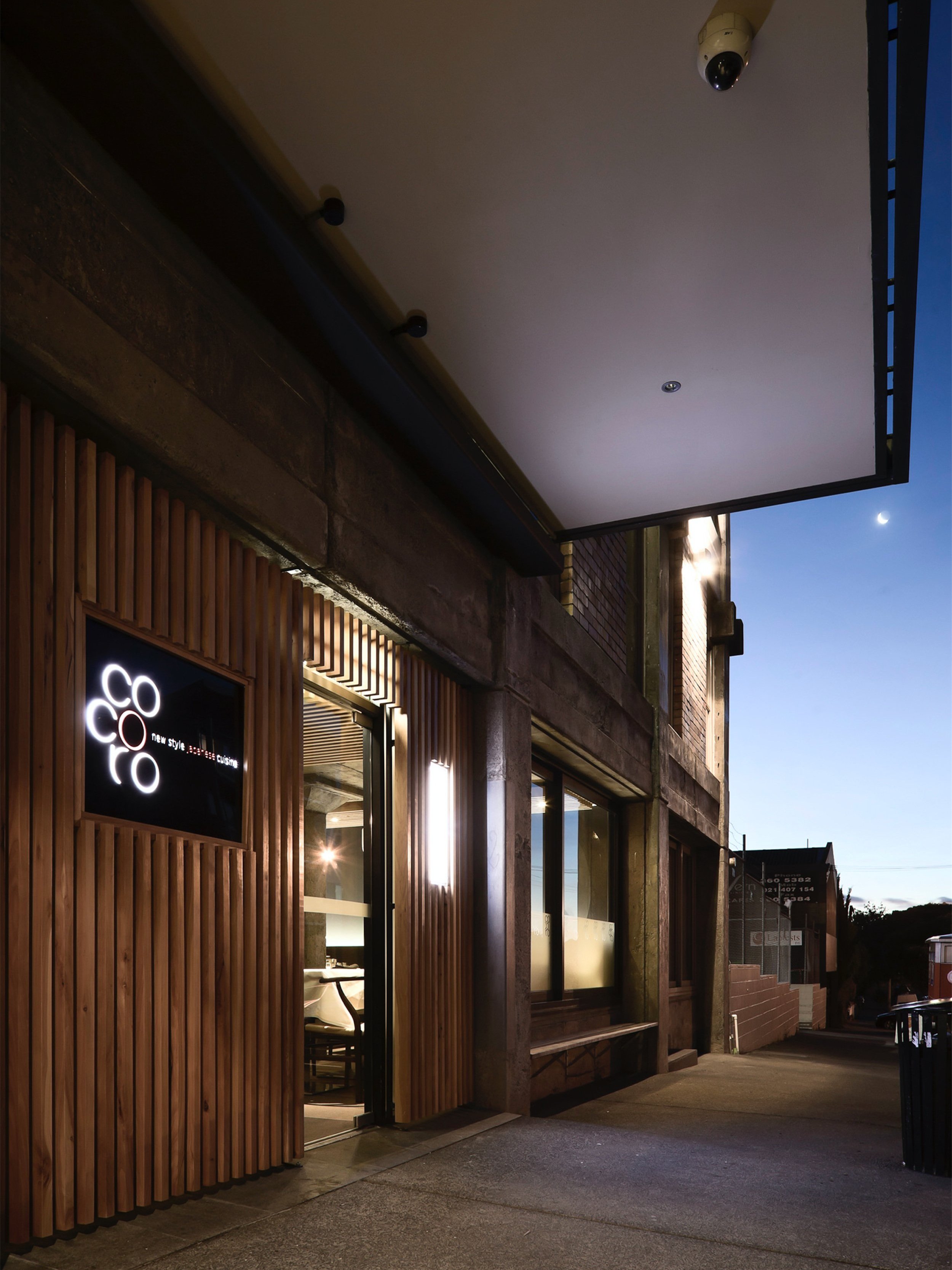 The entry down the side lane, the Cocoro sign lit on dark board