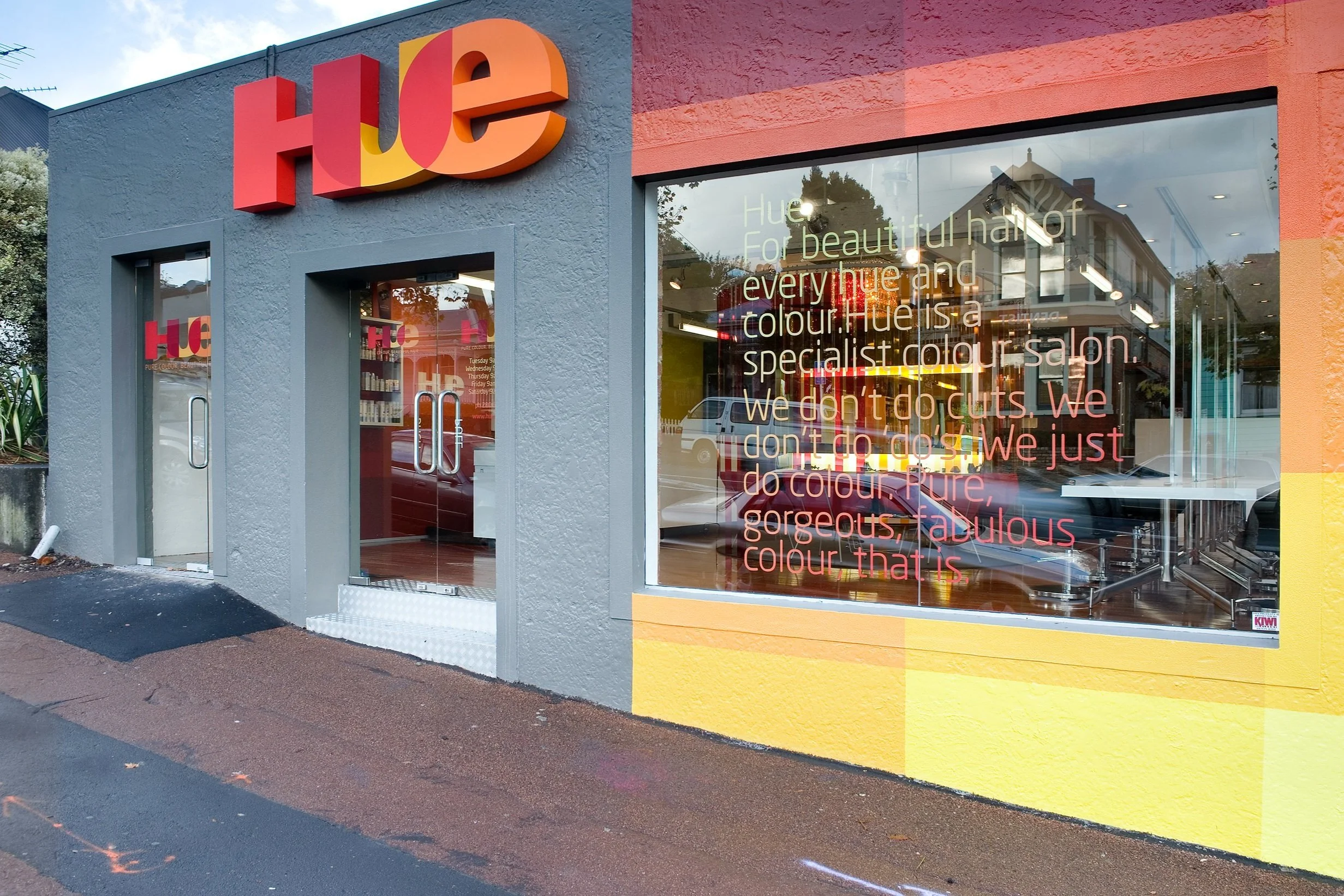 The shopfront, the Hue sign and window lettering on a grey street front