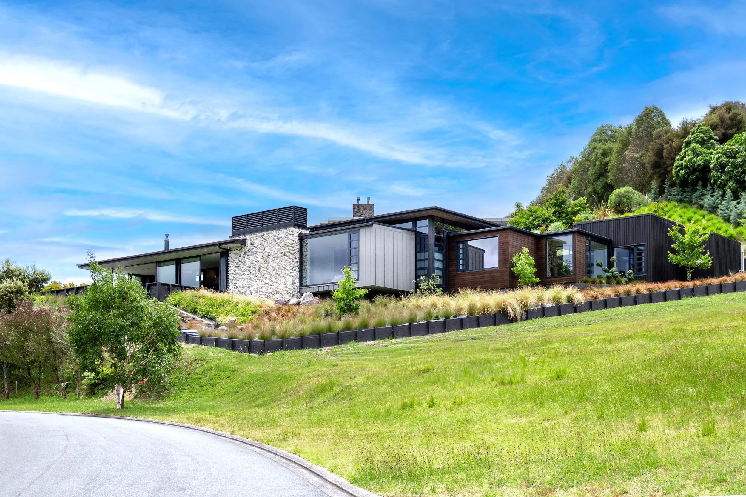 Kinloch House approached from the driveway, its dark cladding and schist set low into the hillside