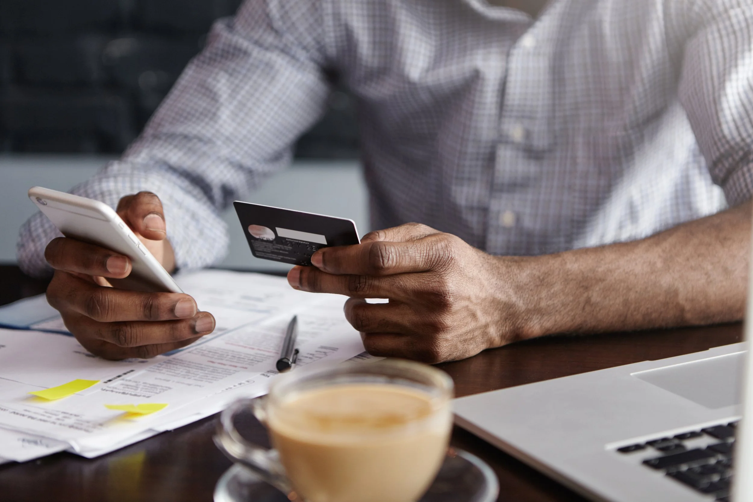close-up-shot-african-man-s-hands-holding-mobile-credit-card.jpg
