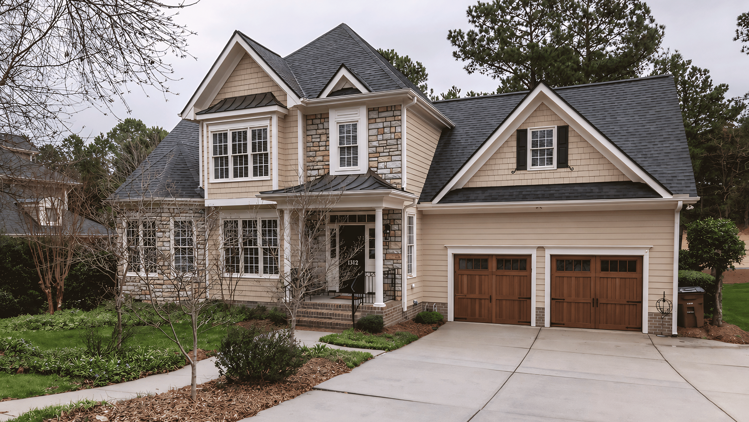 A modern two-story suburban house with beige and stone exterior, dark gray roof, white trim, and a wooden garage door, surrounded by trees and a landscaped yard with a sidewalk and driveway.