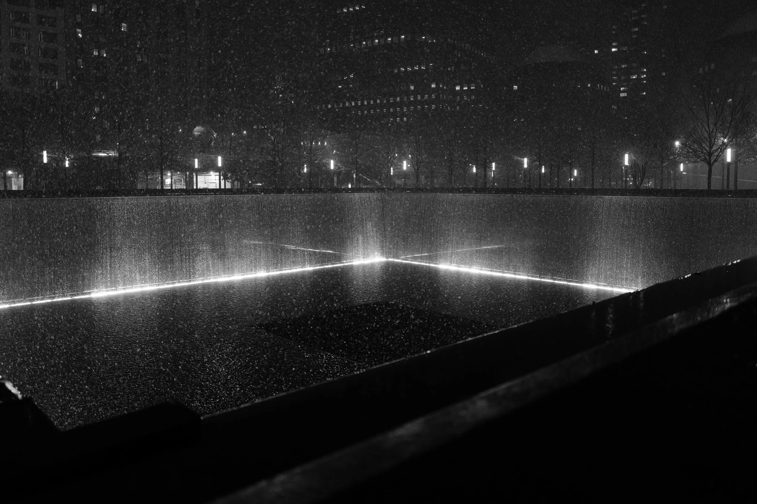 Ce qui semble être un mémorial commémoratif de la chute du mur de Berlin, vu la forme caractéristique du monument avec un fond noir et la lumière au centre