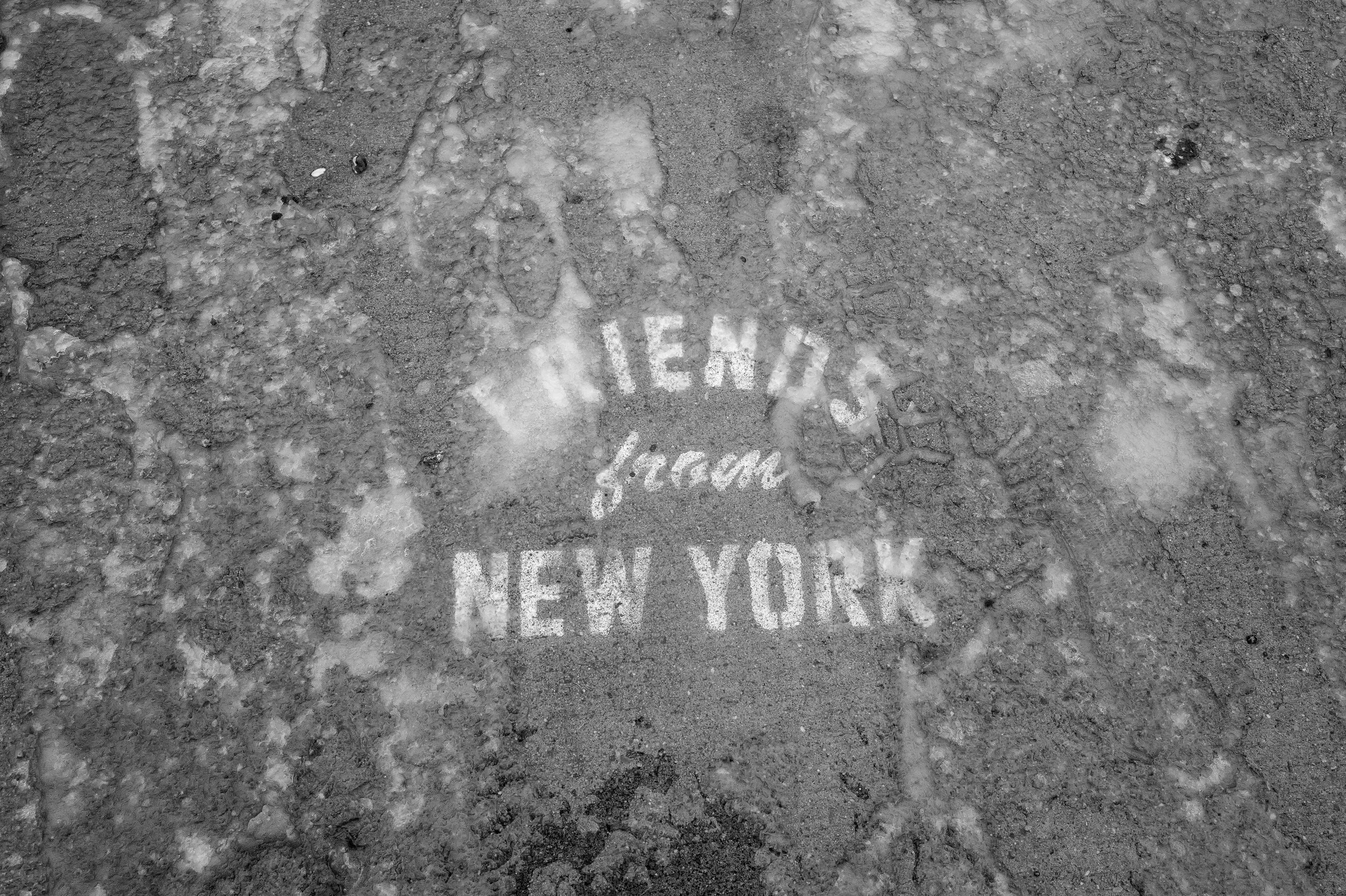 Empreinte de chaussure sur le sol avec l'inscription 'TENNIS from NEW YORK' en peinture blanche.