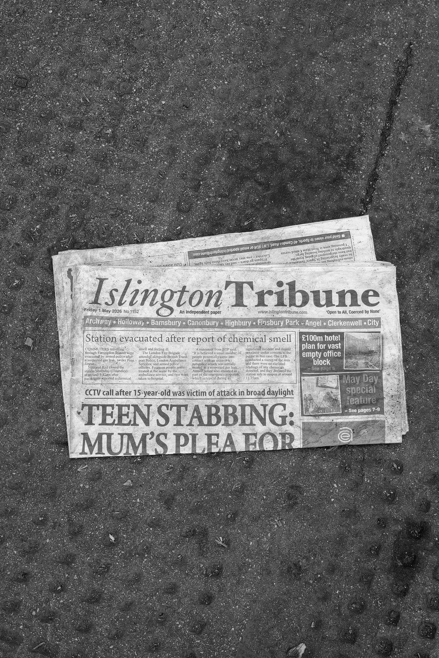 Un journal intitulé "Islington Tribune" posé sur un sol en béton. La première page du journal affiche un titre en gros caractères : "TEEN STABBING : MUM'S PLEA FOR".