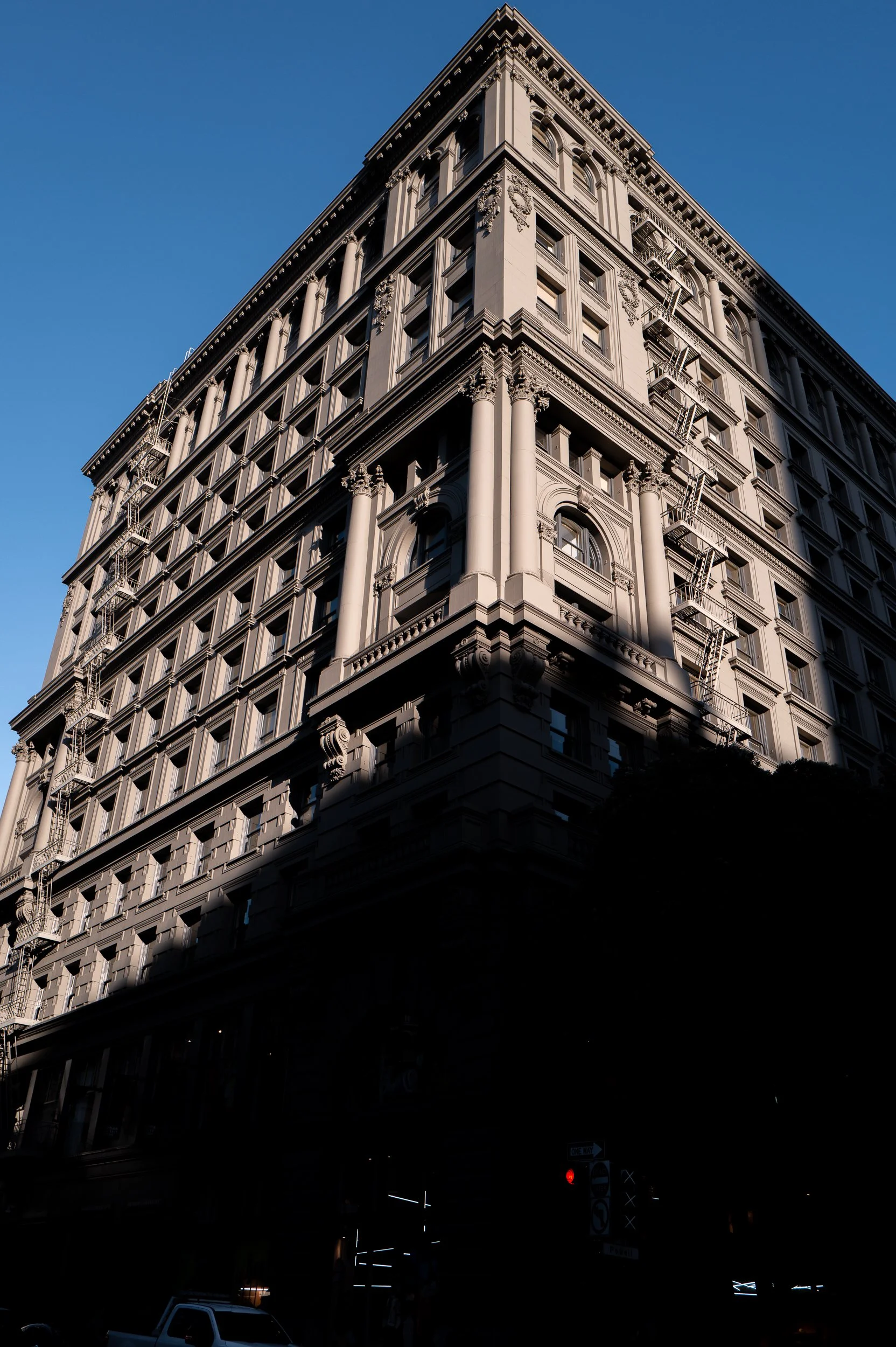 Vue d'un bâtiment ancien avec architecture détaillée, colonnes et fenêtres, sous un ciel bleu.