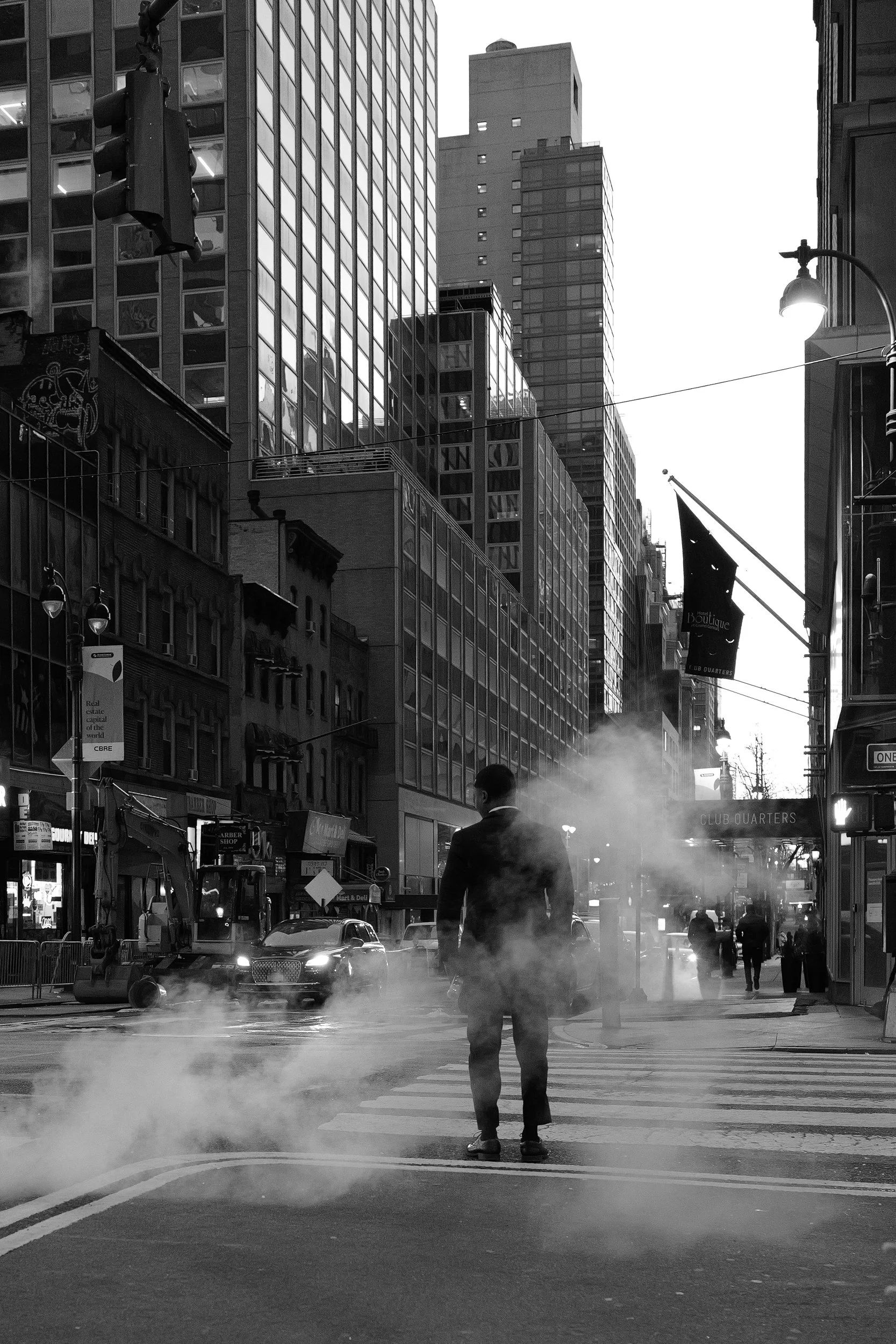 Une rue urbaine animée avec un homme marchant au centre, entouré de bâtiments modernes et anciens, avec de la vapeur ou de la fumée sortant du sol