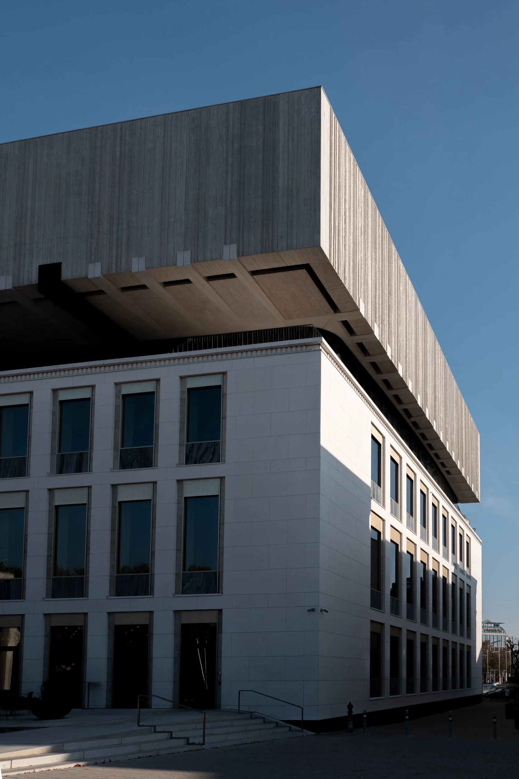 Bâtiment moderne avec une architecture unique, combinant un structure en béton avec un dessin géométrique, sous un ciel clair.
