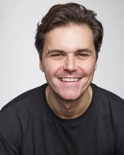 Ben Lifton. A smiling man with dark hair and a black shirt, smiling at the camera.