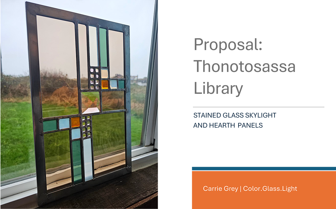 A stained glass skylight with colorful panels in shades of green, orange, light blue, and clear glass, leaning against a window with a view of a grassy outdoor area.