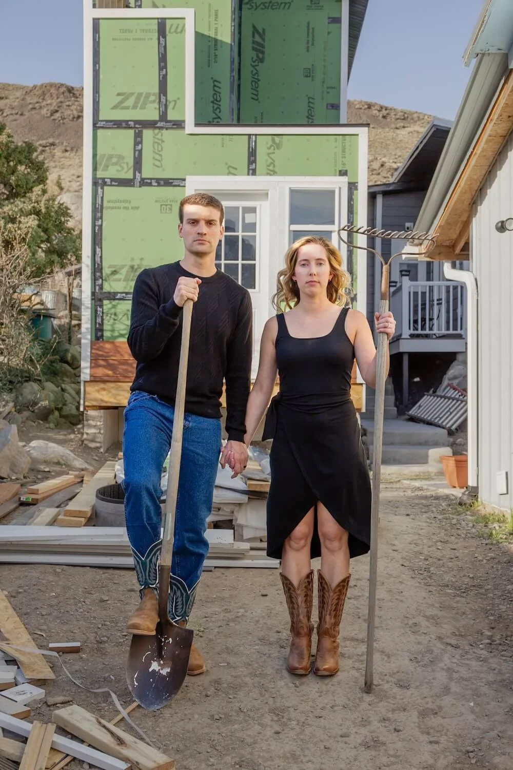 man and woman holding shovel and pitchfork at construction site