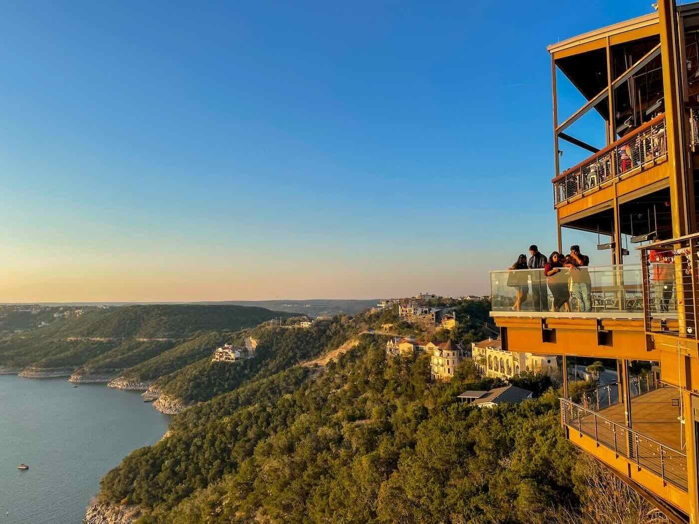 multi story restaurant on lake shore at sunset