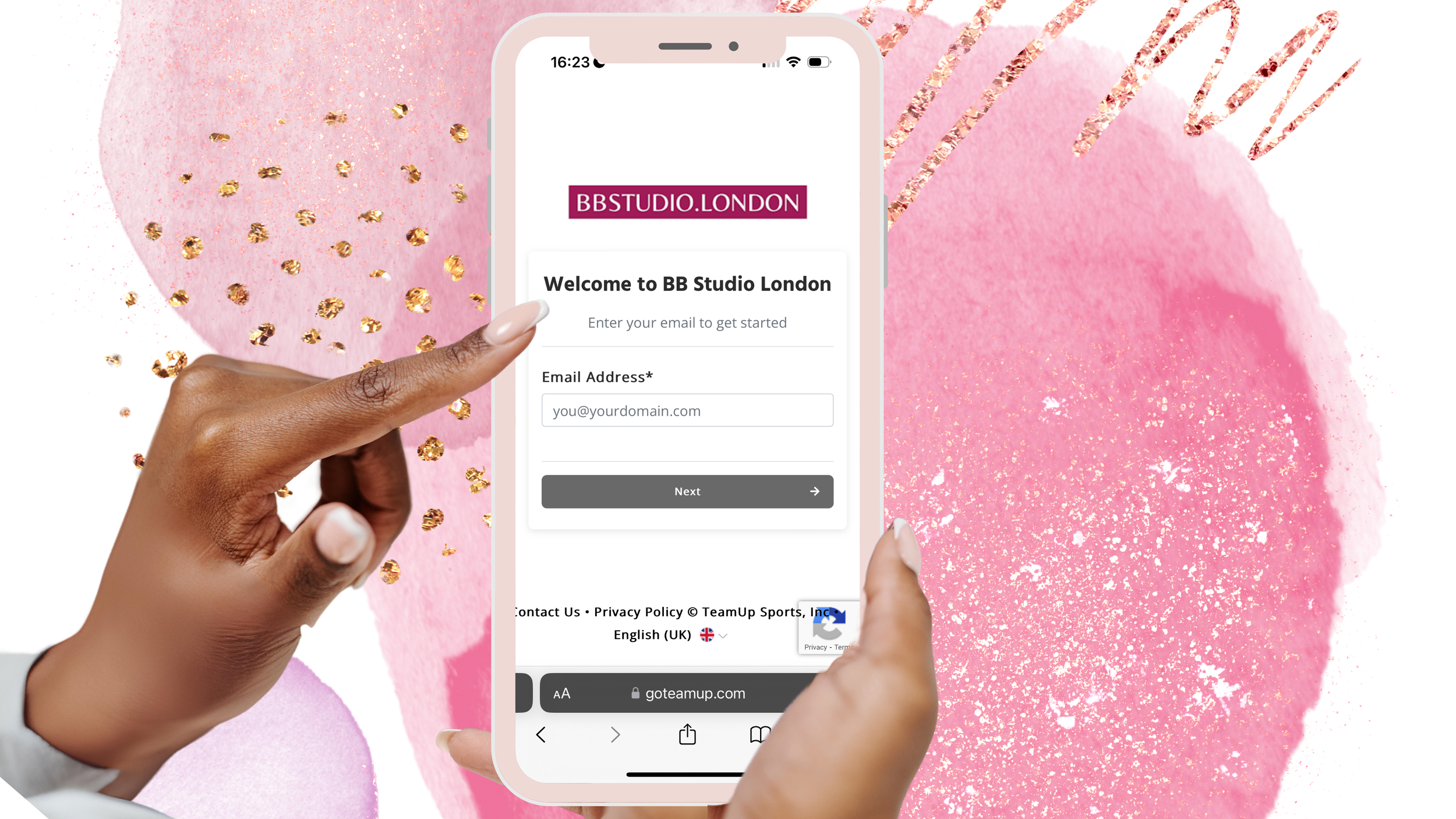 Person with well-manicured nails pointing to a mobile phone screen showing the BB Studio London sign-in page, with a pink and gold decorative background.
