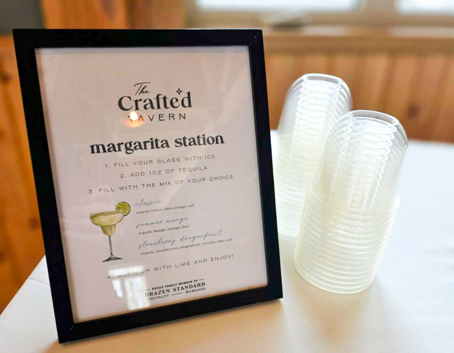 Sign for the Margarita Station at The Crafted Tavern with instructions for making margaritas, and a stack of clear plastic cups next to it.