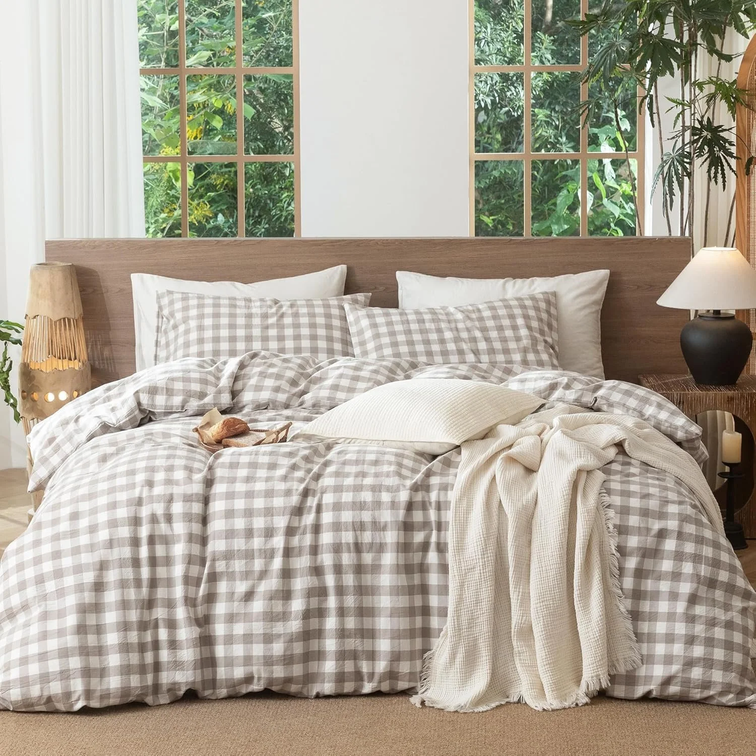 Washed cotton gingham duvet cover in taupe and cream layered with neutral bedding on a made bed