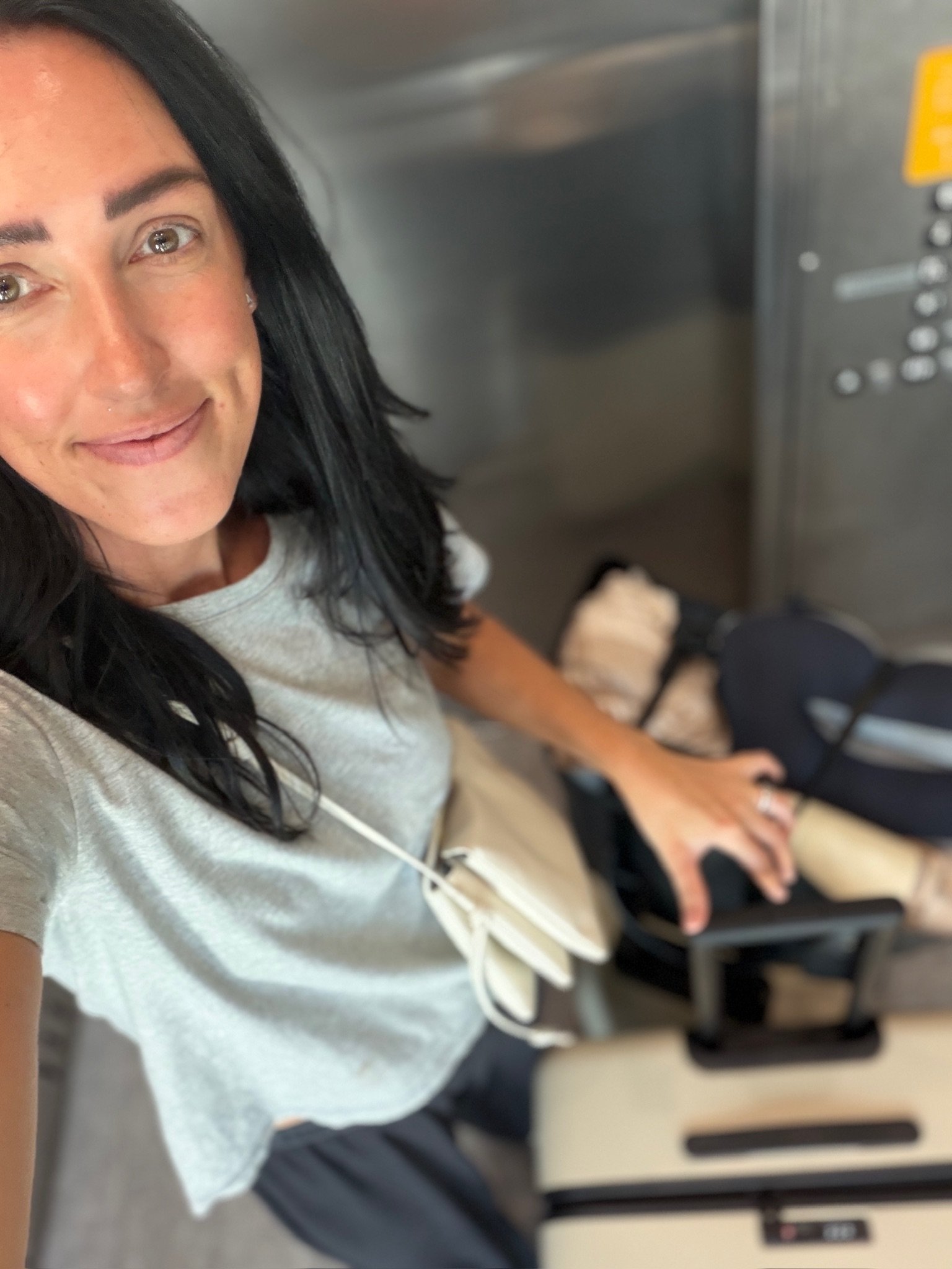 Light blue tee and soft grey travel pants worn with luggage on the way to Italy