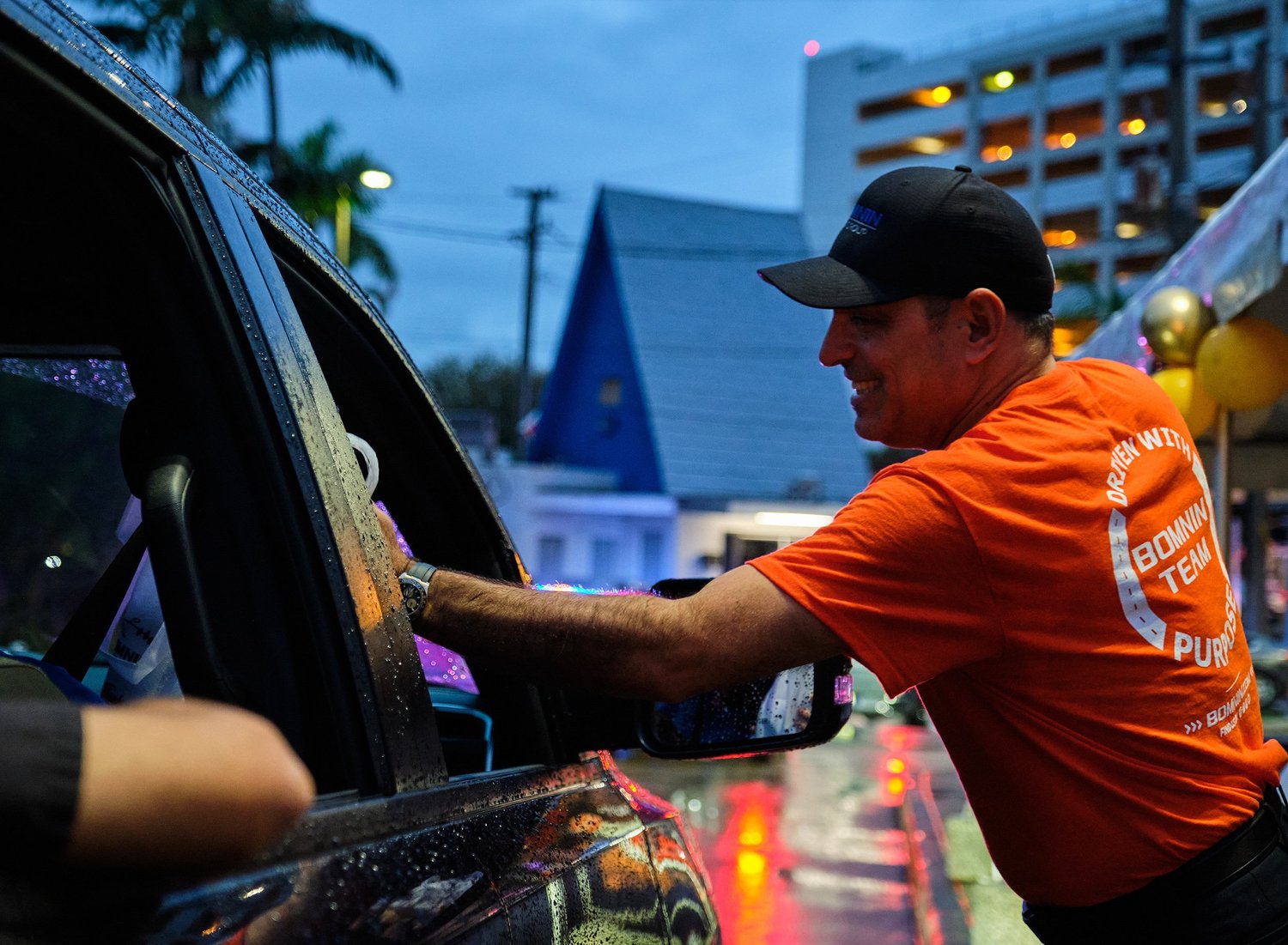 A Bomnin associate handing a turkey to a family during the Thanksgiving giveaway