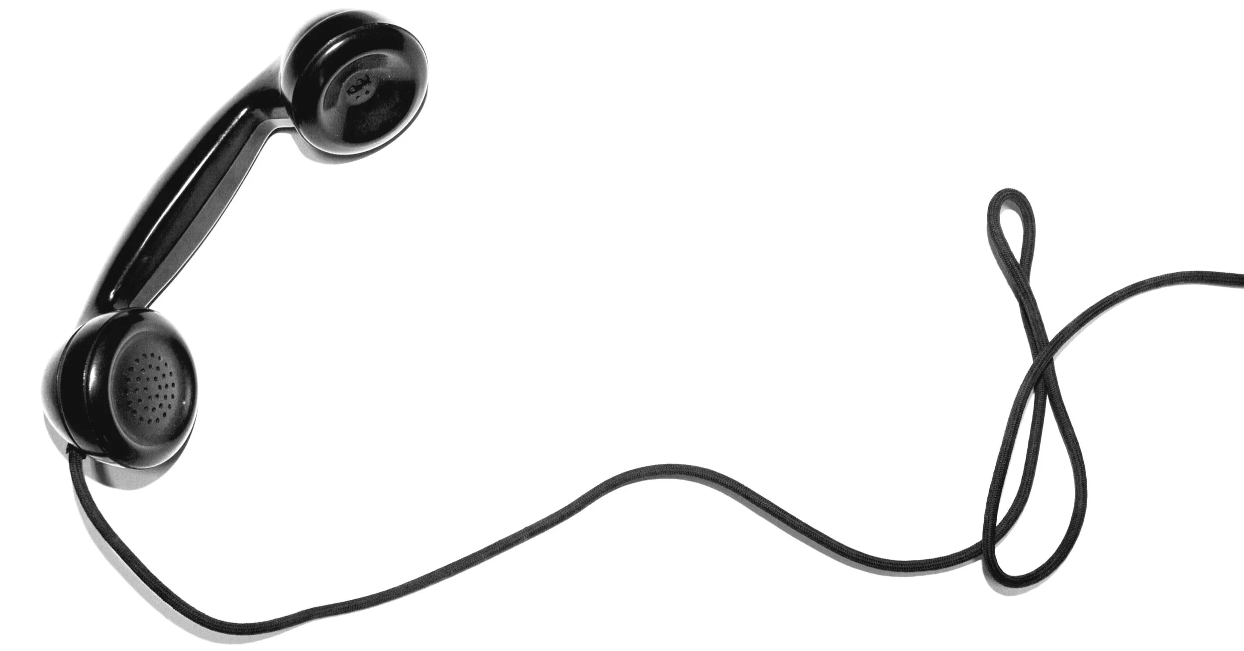 Black vintage telephone handset with cord on white background.