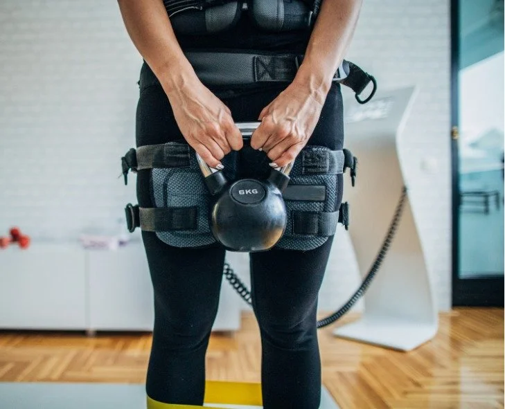 Renforcement musculaire avec kettlebell en combinaison EMS