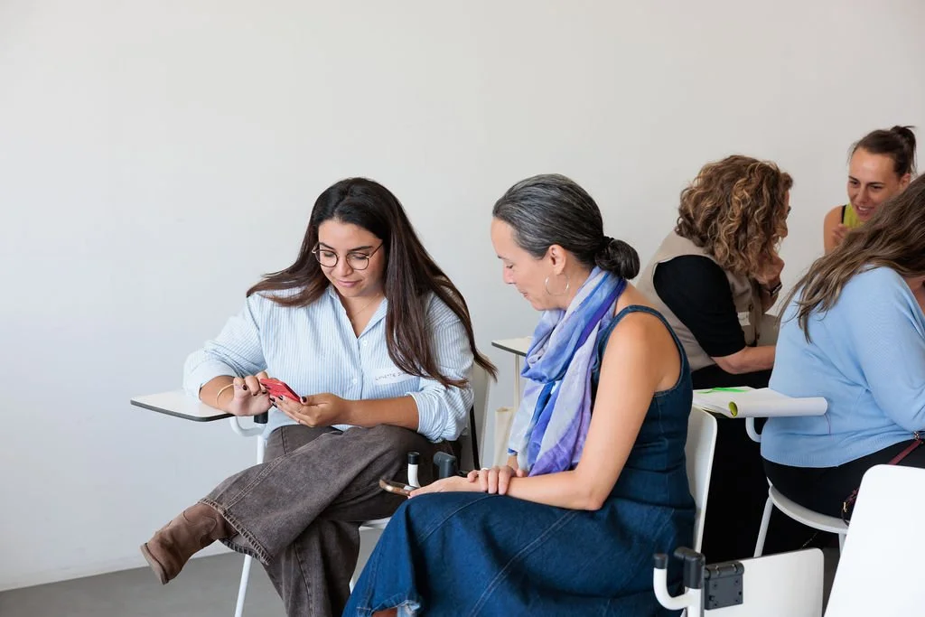 Dos participantes consultan un teléfono durante una dinámica del encuentro LIDERA