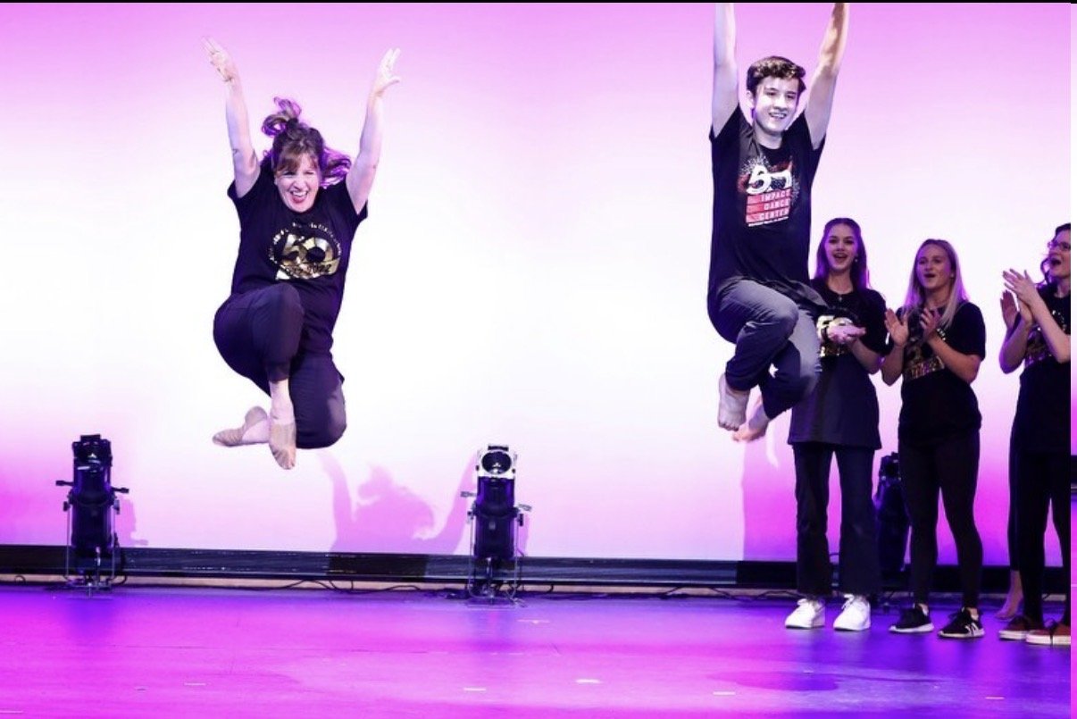 Impact alumni doing tuck jumps onstage