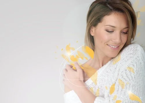 Smiling woman in white sweater with abstract yellow design