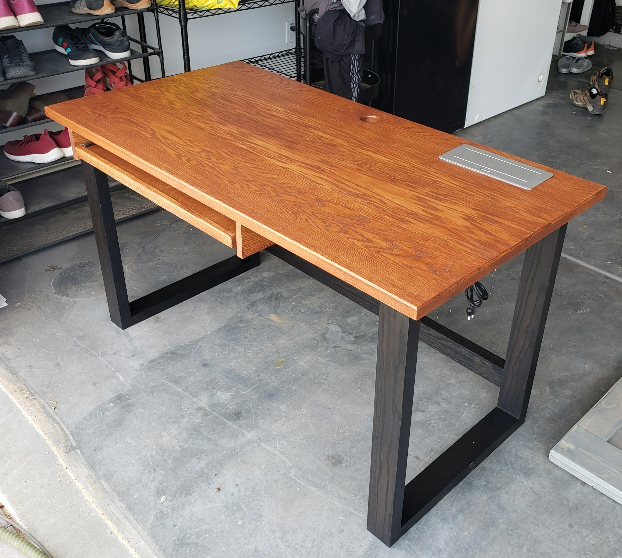 Stained Oak Desk with Black Base, Slide-Out Keyboard Tray, and Collapsible Plug Port