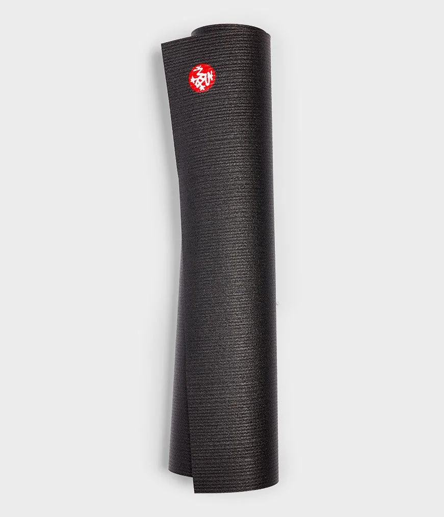 A rolled-up black yoga mat with a red and white logo on the top, standing upright against a plain light gray background.
