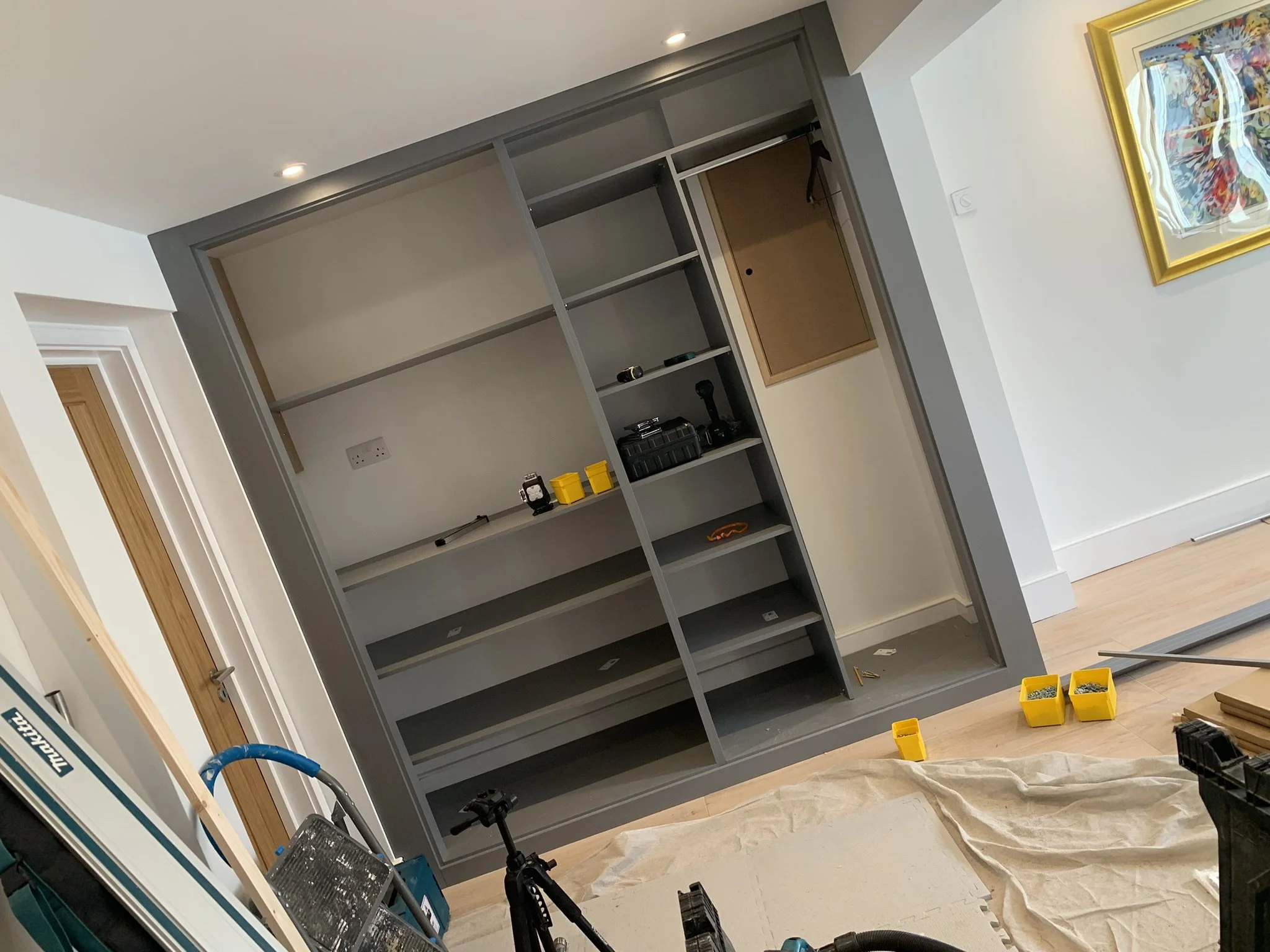 Room under renovation with built-in shelving, tools, and materials.