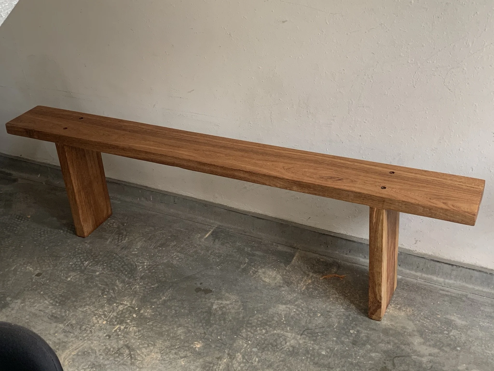Wooden bench against a wall