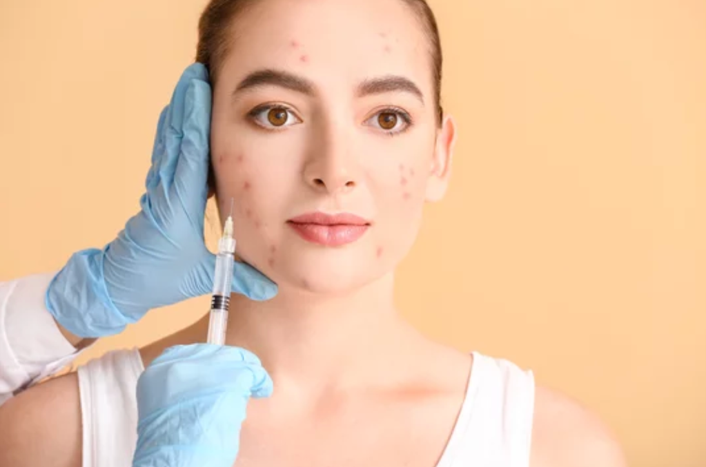 young girl with acne blemishes and a pair of gloved hands giving an injection