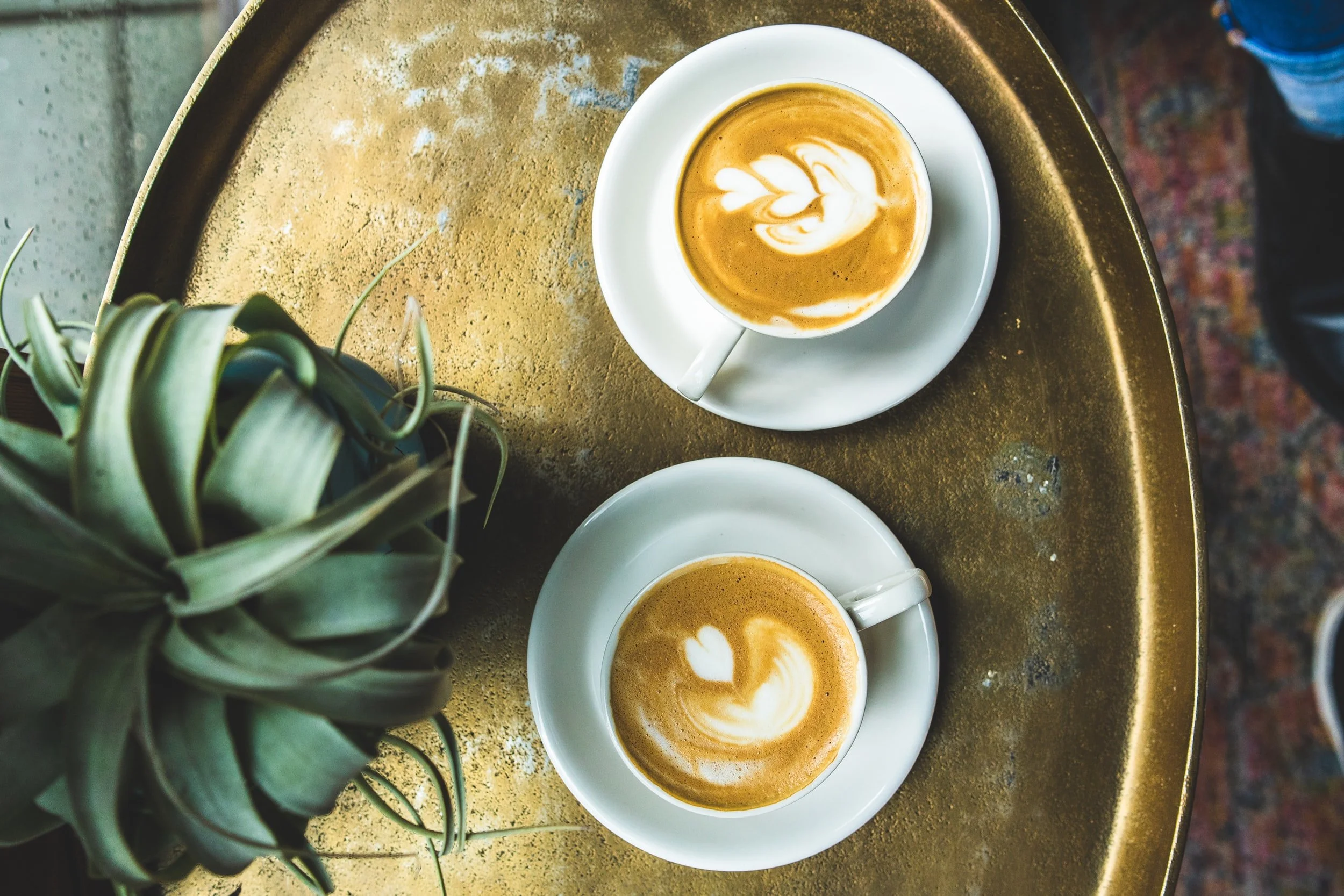 Two mugs of cappaccino pictured from above.
