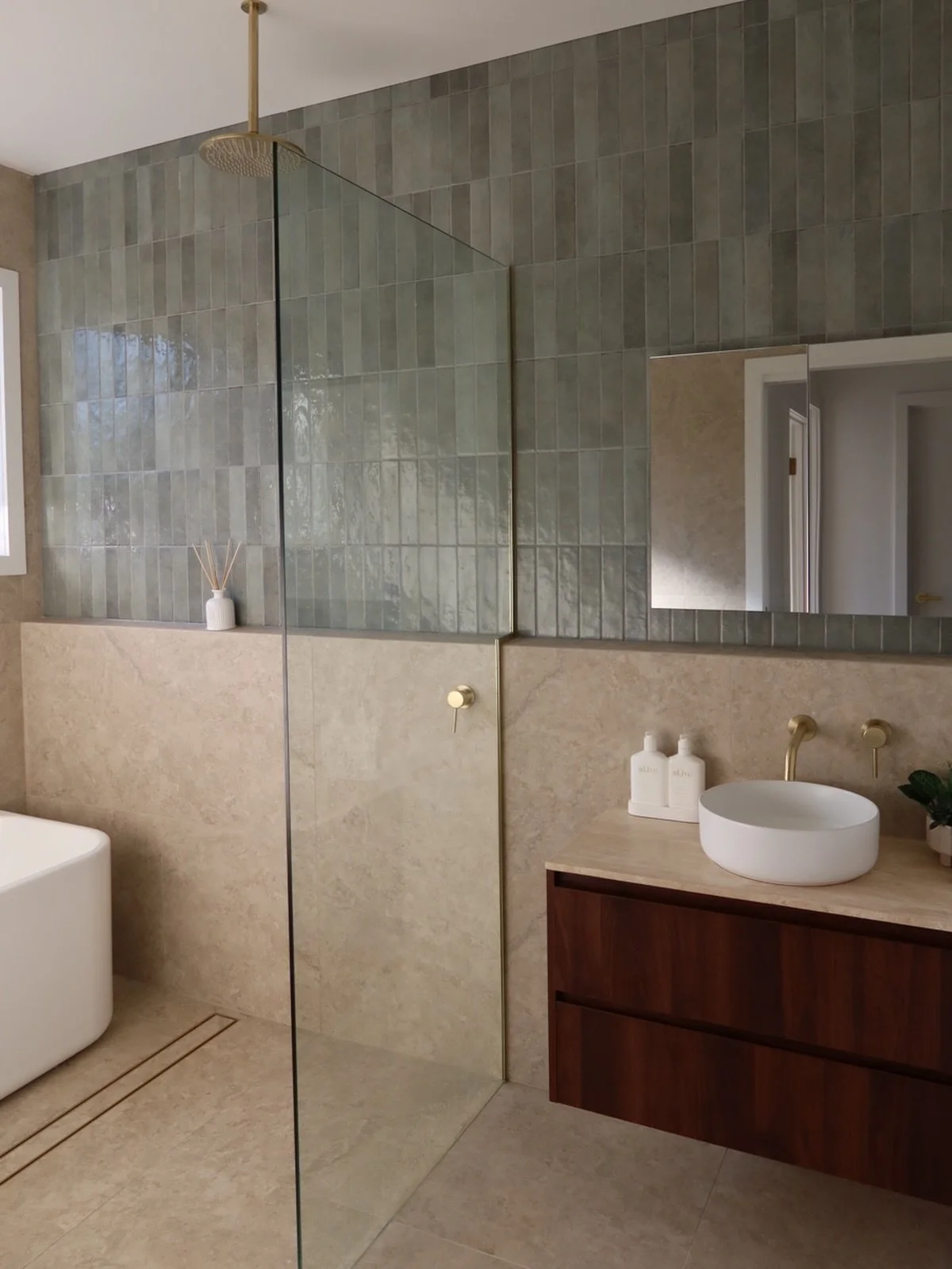 Main bathroom in our recent new build project features forest green subways, travertine floor and wall tiles, brushed brash fixture from @abiinteriors as well as walnut vanity. 🙌🏽