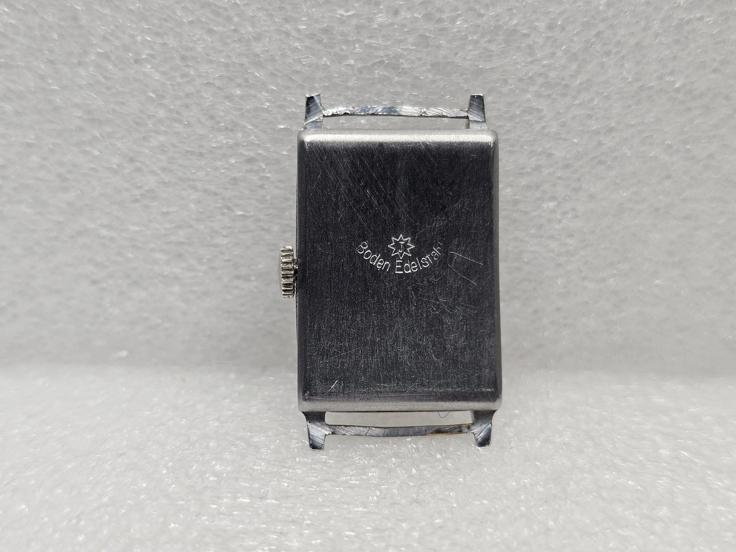 1950s Junghans tank-style dress watch with black gilt dial, sub-seconds register, and chrome-plated rectangular case on black textile strap