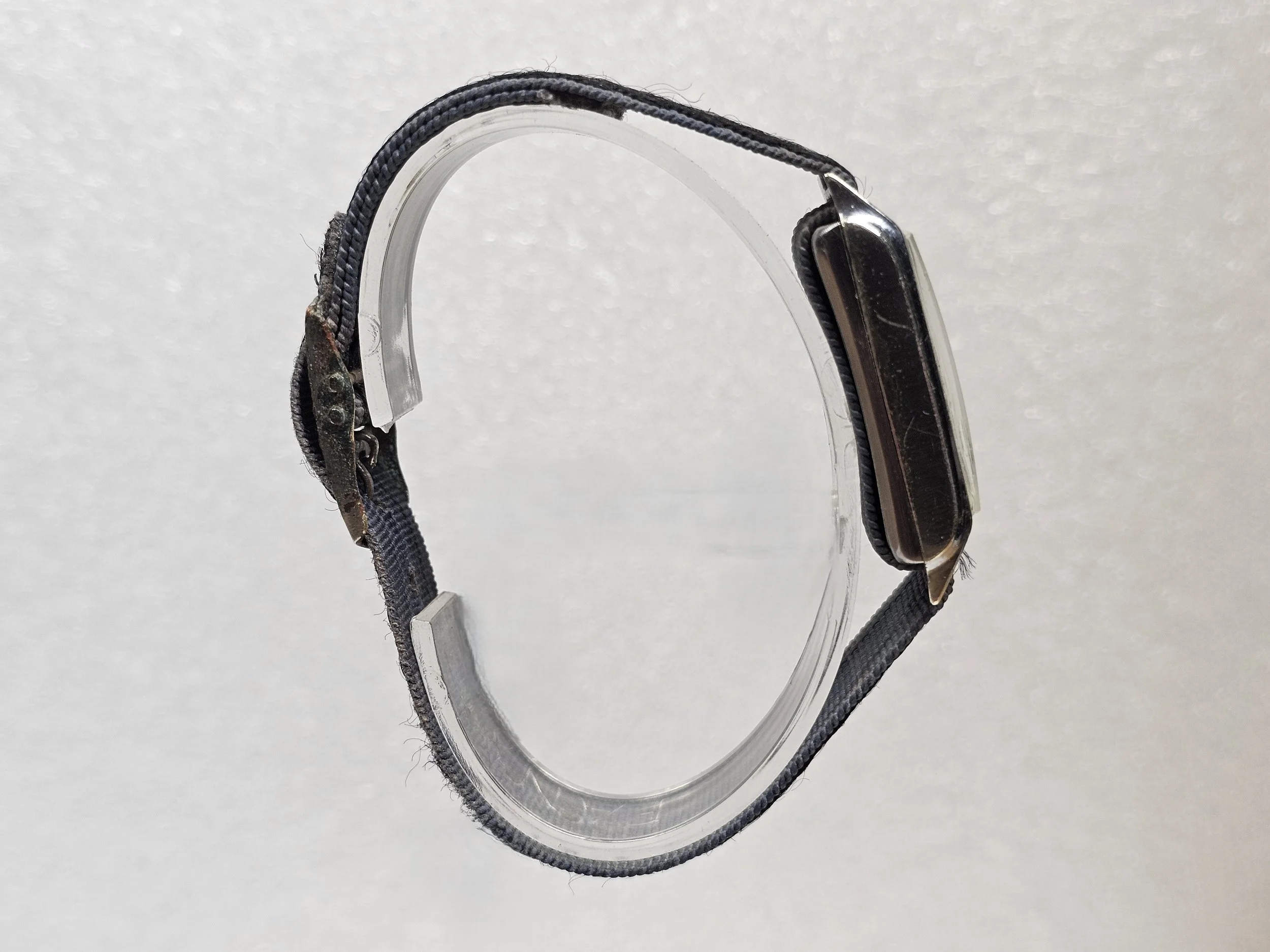 1950s Junghans tank-style dress watch with black gilt dial, sub-seconds register, and chrome-plated rectangular case on black textile strap