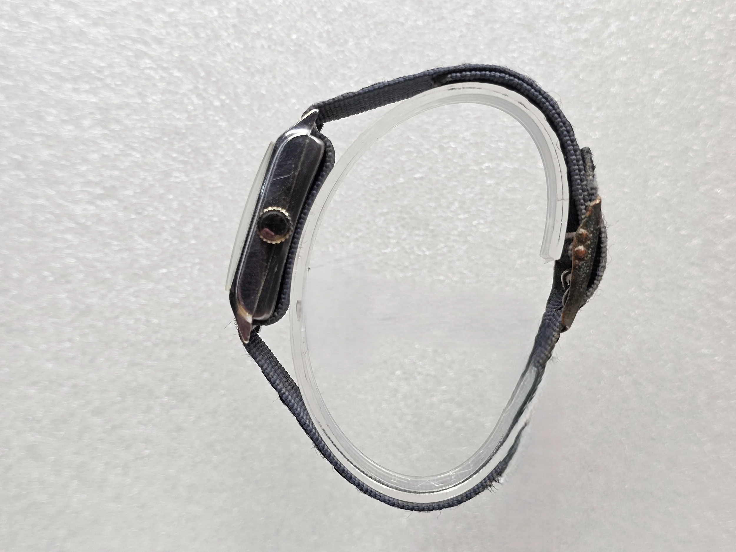 1950s Junghans tank-style dress watch with black gilt dial, sub-seconds register, and chrome-plated rectangular case on black textile strap