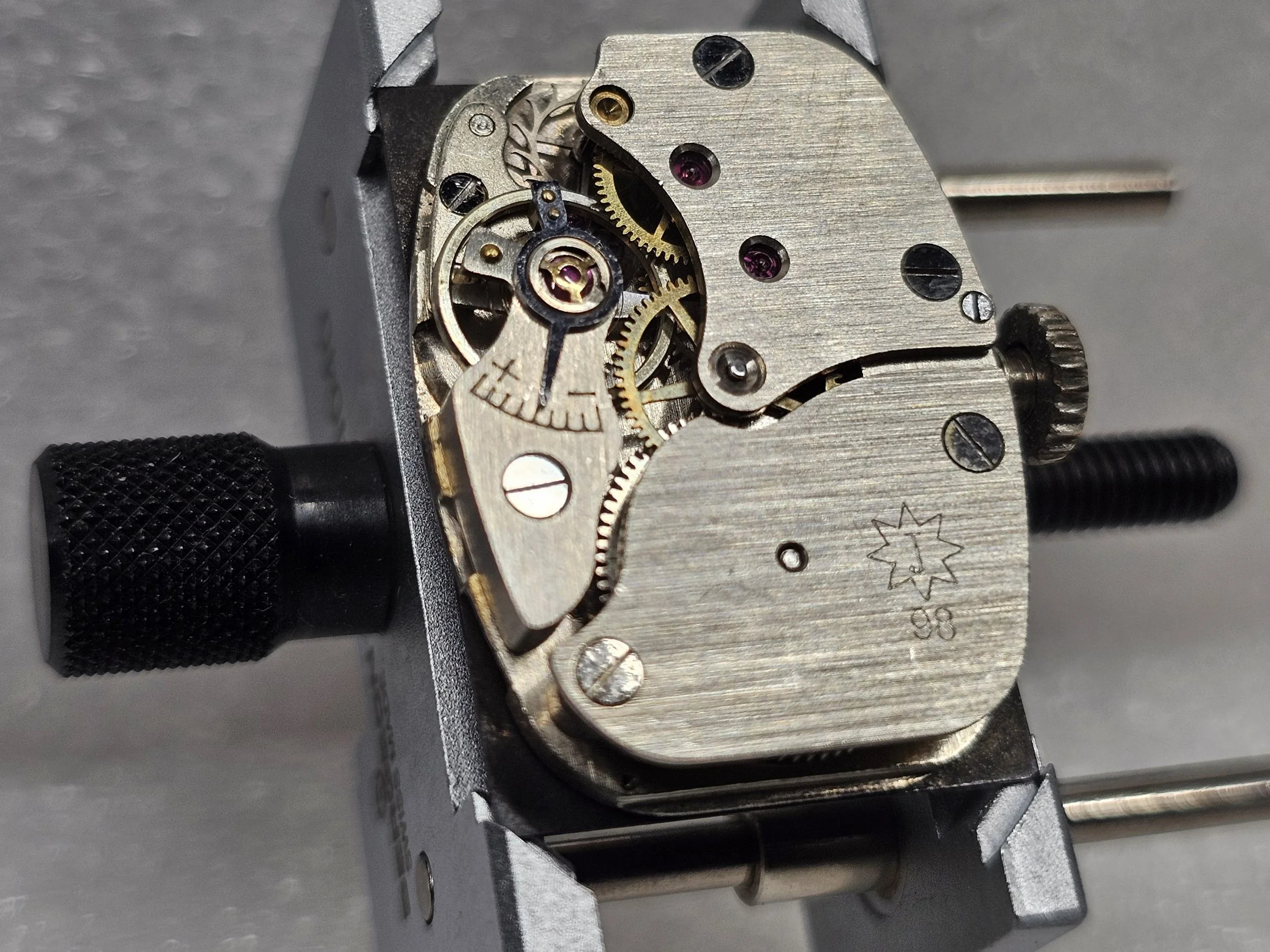 1950s Junghans tank-style dress watch with black gilt dial, sub-seconds register, and chrome-plated rectangular case on black textile strap